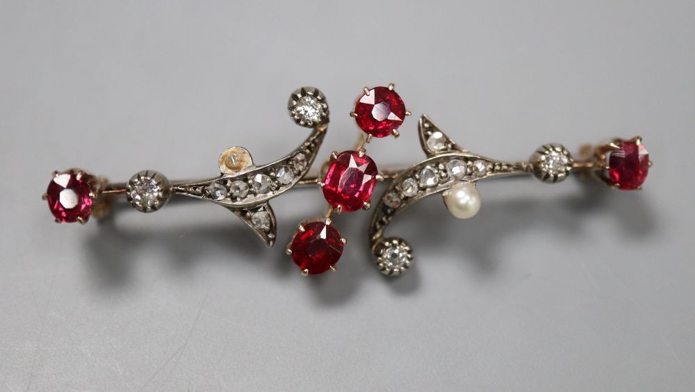 A yellow and white metal, ruby, diamond and seed pearl scrolling bar brooch (pearl missing), 46mm, gross 5.1 grams.